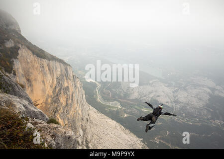 Cavalier Base mid air juste après cliff jump pendant temps de brouillard, Brento, Vénétie, Italie Banque D'Images