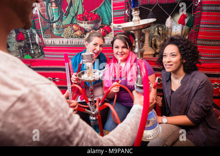 Groupe de travail sur les femmes et les hommes d'être servi dans un narguilé shisha cafe Banque D'Images