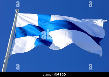 Battant pavillon de la Finlande contre le ciel bleu. Banque D'Images