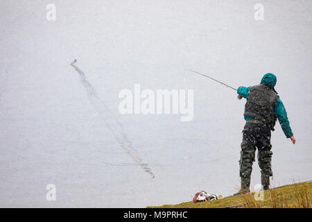 Le Nord du Pays de Galles, Royaume-Uni 28 mars 2018, Météo France : une nouvelle vague de neige et des températures plus froides du nord du Pays de Galles avec plus de hits attendus de la neige dans la semaine à venir. Un pêcheur de mouche bravant la neige froid à la pêche Llyn Brenig, au nord du Pays de Galles © DGDImages/Alamy Live News Banque D'Images