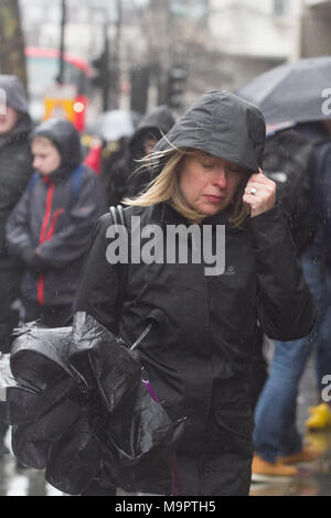 London UK. 28 mars 2018. Les piétons à l'abri de la pluie froide dans le Strand sur une journée froide humide Banque D'Images