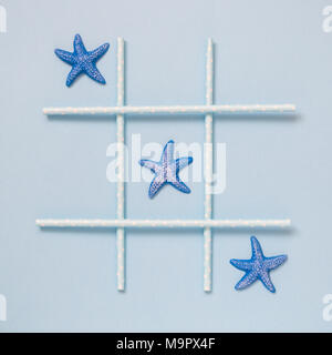 Tic Tac Toe fait d'étoiles de mer et des pailles sur fond bleu pastel télévision lay concept minimal Banque D'Images