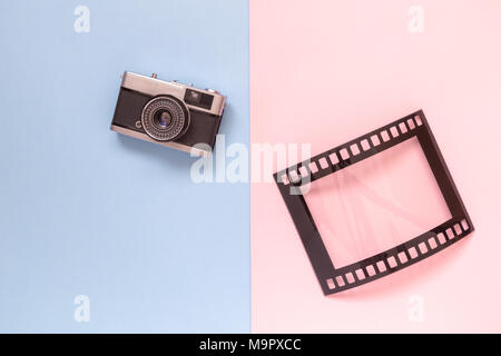 Film rétro cadre photo et caméra isolé sur fond pastel coloré concept créatif minime. Banque D'Images