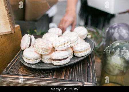 Macarons fraises rose pastel. Dessert délicat française pour le petit déjeuner dans la lumière du matin sur une table en bois. Profondeur de champ. Réception de Mariage Banque D'Images