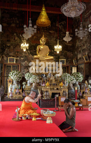 Le moine bouddhiste bénit les croyants avant de remettre un ruban, Obosot la chance de Wat Arun, Temple de l'aube, Bangkok, Bangkok Yai Banque D'Images