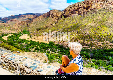 Senior woman profité de la vue de l'Huisrivierpas, entre Ladismith et Calitzdorp dans le petit Karoo de la province du Cap-Occidental en Afrique du Sud Banque D'Images