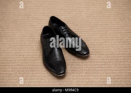 Noir brillant moderne mans chaussures avec lacets sur fond clair, close-up Banque D'Images