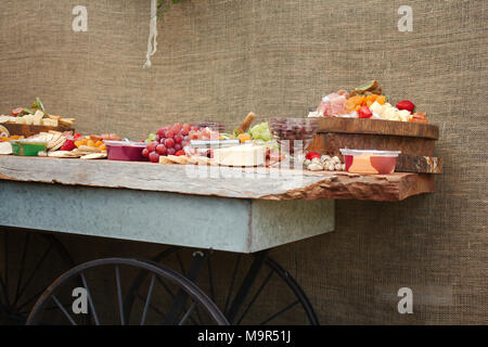 Un lumineux colorés & sélection de fruits, fromages, charcuteries, trempettes et craquelins réparties sur une belle planche de bois. Banque D'Images