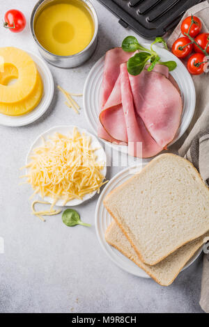 Ingrédients pour faire des toasts grillés sandwich hawaii avec jambon, ananas, tomate et fromage. L'été en bonne santé food concept avec de l'espace libre pour le texte. Banque D'Images