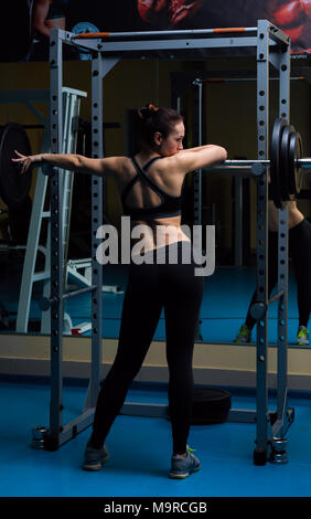 Femme avec la barre dans la salle de sport Banque D'Images