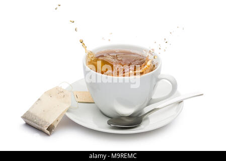 Tasse de thé avec des éclaboussures et sachet de thé sur fond blanc Banque D'Images