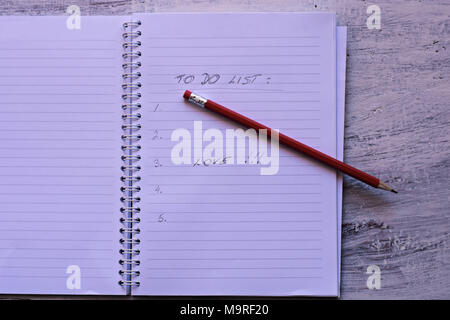 Crayon rouge avec un ordinateur portable sur une table en bois Enregistrer des idées créatives sur le papier. L'équipement de base avant de l'ordinateur. Sur l'arrière-plan de table rustique Banque D'Images