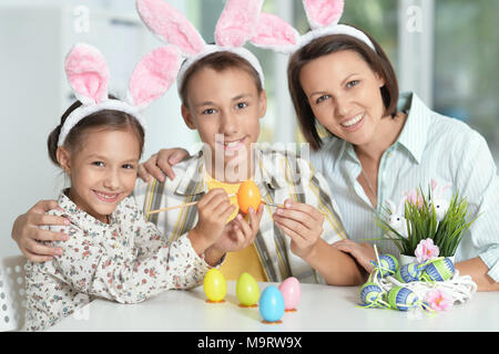 Mère avec son fils et sa fille portant des oreilles de lapin de Pâques oeufs peinture Banque D'Images