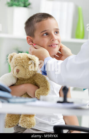 Médecin examine petit boy,little boy holding a teddy bear Banque D'Images