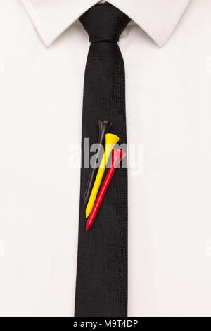 Le détail de la chemise blanche et cravate noire avec le golf design. Golf tees dans la couleur du pavillon belge sur la cravate noire. Banque D'Images