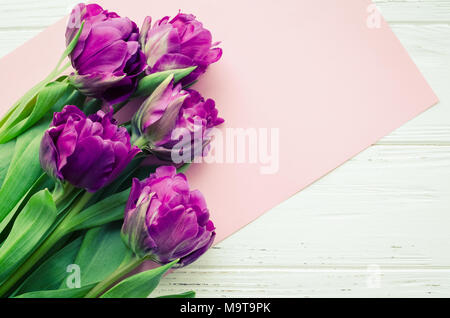 Fleurs tulipe Ultraviolet sur shabby chic blanc fond de bois. Bouquet de tulipes au printemps violet. Heureuse Fête des Mères. Carte de voeux de la Saint-Valentin. Int Banque D'Images