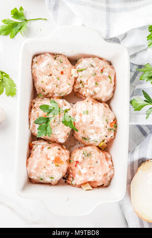 Des matières premières ou de poulet boulettes de dinde dans le plat de cuisson sur fond de marbre blanc. Copier l'espace. haut de page Fermer Banque D'Images