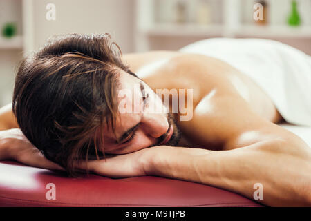 Jeune homme jouit de massage sur un soin spa. Banque D'Images
