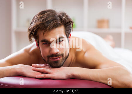 Jeune homme jouit de massage sur un soin spa. Banque D'Images
