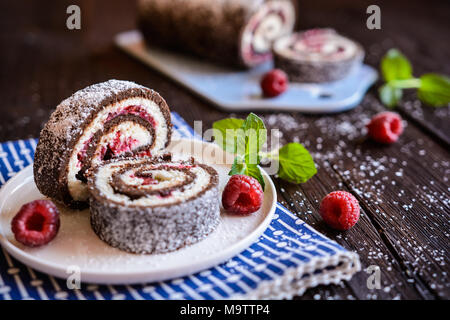 Chocolat sans cuisson gâteau rouleau rempli de crème de noix de coco et framboise Banque D'Images