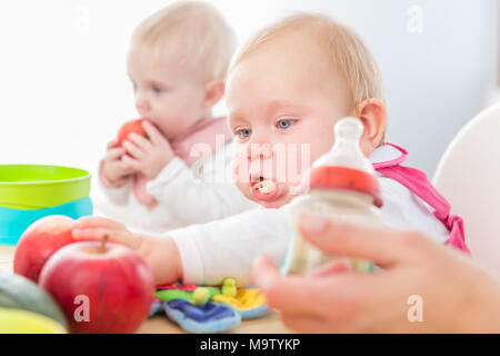 Cute baby girl manger sain aliments solides dans une garderie moderne Banque D'Images