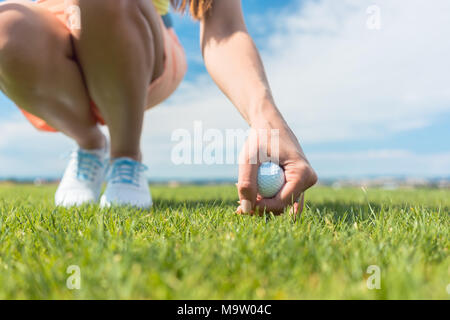 Détail de la main d'une femme joueur tenant une boule au-dessus de l'herbe Banque D'Images