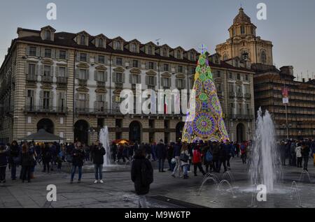 Turin, Italie, Piémont, le 8 décembre 2017. La Piazza Castello ornée avec sa caractéristique de l'arbre de Noël, les fontaines et les touristes. Banque D'Images