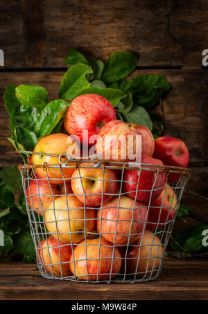 Un panier de pommes rouges et un fond de bois Banque D'Images