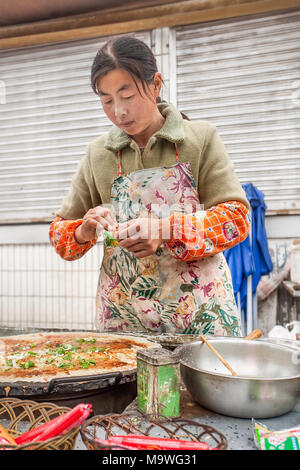 BEIJING-OCT. 10, 2010. Femme vendeur vend des crêpes, appelé Jiang Bing, sur la rue du marché. Dernières années, Pékin a réprimé des vendeurs de rue, de plomb Banque D'Images