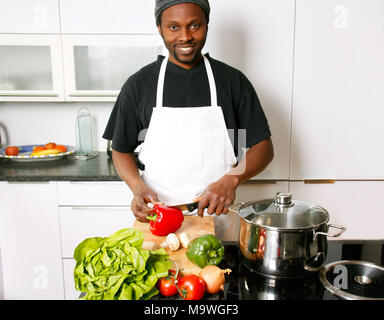 Un jeune smiling chef cuisiner dans la cuisine Banque D'Images