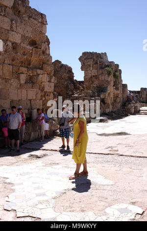 GUIDE D'UNE FEMME À LA TÊTE D'UN GROUPE DE TOURISTES DANS LES ANCIENNES Ruines de Salamis. Chypre du Nord Banque D'Images