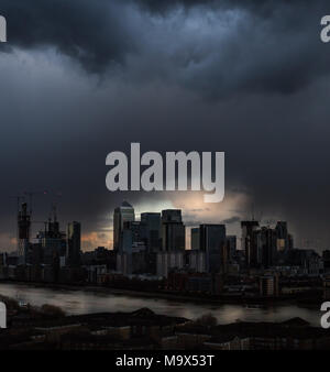 Londres, Royaume-Uni. 28 mars, 2018. Météo France : La dernière lumière brise une sombre et dramatique ciel du soir juste avant que le soleil se couche complètement après une brève tempête de pluie sur l'Est de Londres y compris les bâtiments du parc d'affaires de Canary Wharf. Crédit : Guy Josse/Alamy Live News Banque D'Images