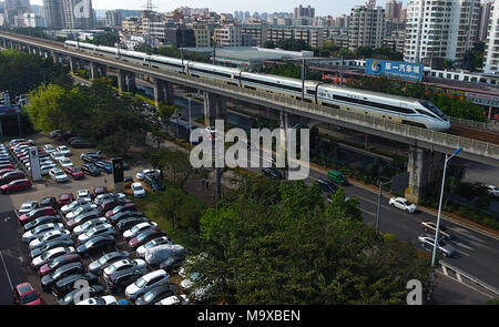 Haikou. Mar 15, 2018. Photo prise le 15 mars 2018 montre un train rapide passant Haikou City, province de Hainan en Chine du sud. Les 653 km de ligne ferroviaire à grande vitesse encerclant l'île a reçu plus de 25 millions de passagers en 2017. Crédit : Yang Guanyu/Xinhua/Alamy Live News Banque D'Images