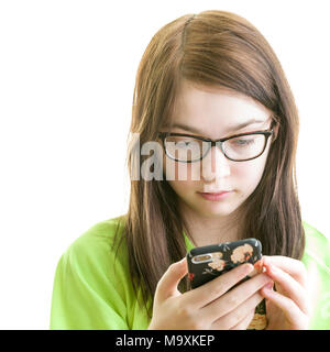 Close up portrait of a brunette young Caucasian teenage girl using smartphone isolé sur fond blanc Banque D'Images