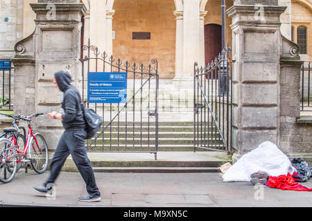 Une personne sans-abri dort sur le trottoir devant l'entrée de la faculté d'histoire de l'université dans la ville d'Oxford, en Angleterre, par une journée d'hiver Banque D'Images
