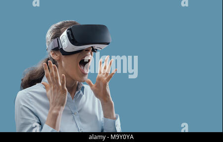 Femme portant un casque VR et connaissent la réalité virtuelle, il est étonné et surpris Banque D'Images