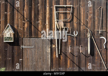 Outils rural ancien accroché sur une porte de grange en bois pour décoration Banque D'Images