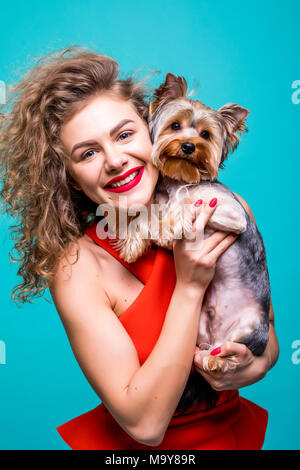 Belle jeune femme avec mignon chien yorkshire terrier, isolé sur fond vert Banque D'Images