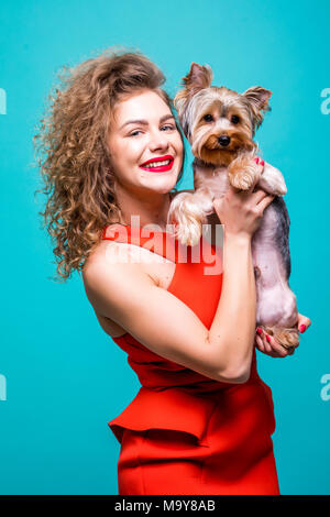 Belle jeune femme avec mignon chien yorkshire terrier, isolé sur fond vert Banque D'Images