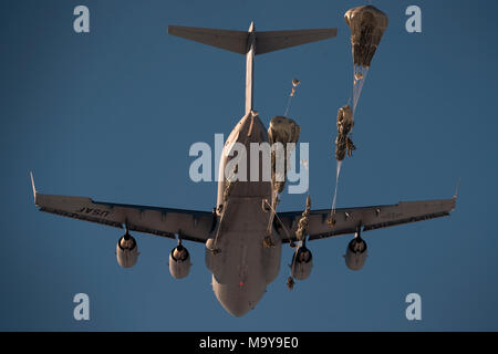 Parachutistes affectés à la 4th Infantry Brigade Combat Team (Airborne), 25e Division d'infanterie de l'armée américaine, l'Alaska, passer d'un Air Force C-17 Globemaster III affecté à la 517e Escadron de transport aérien au cours de l'entraînement en plus de Malemute Drop Zone, Joint Base Elmendorf-Richardson, Alaska, le 22 mars 2018. Les soldats de 4/25 appartiennent à la seule brigade aéroportée américaine dans le Pacifique et sont formés pour exécuter les manœuvres dans les conditions climatiques extrêmement froides/environnements de haute altitude à l'appui de la lutte contre, la formation et les opérations de secours. (U.S. Photo de l'Armée de l'air par la Haute Airman Javier Alvarez Banque D'Images