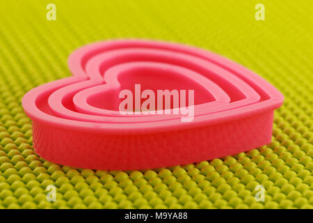 Coeur en plastique rose sur tapis anti dérapant