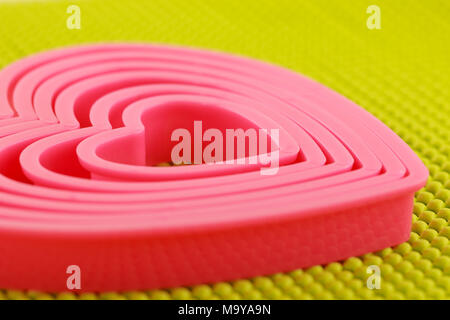 Coeur en plastique rose sur tapis anti dérapant