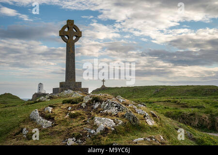 Avis de croix celtique sur l'île Llanddwyn Ynys dans Anglesey avec Twr Mawr Phare en paysage en arrière-plan Banque D'Images