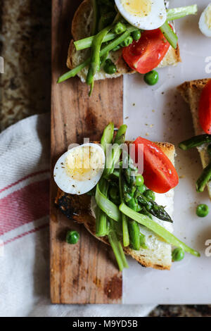 Oeufs de cailles, petits pois et asperges crostini Banque D'Images