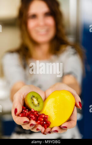 Femme offrant des fruits exotiques, son visage est en arrière-plan flou Banque D'Images