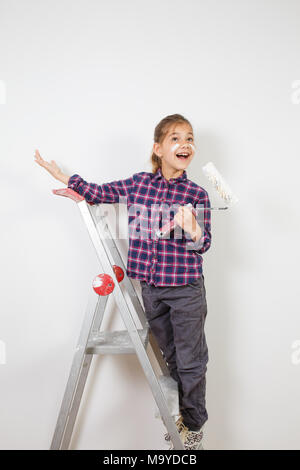 Fille de l'adolescence à l'aide d'un pinceau peintre sur mur blanc dans la chambre. La réparation à la maison Banque D'Images