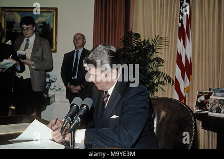 Washington DC., USA, le 6 mars 1985, le président Ronald Reagan est assis à son bureau dans le bureau ovale de la Maison Blanche, la signature du message de veto pour le crédit agricole et les soulager la famine en Afrique Bill Crédit : Mark Reinstein/MediaPunch Banque D'Images