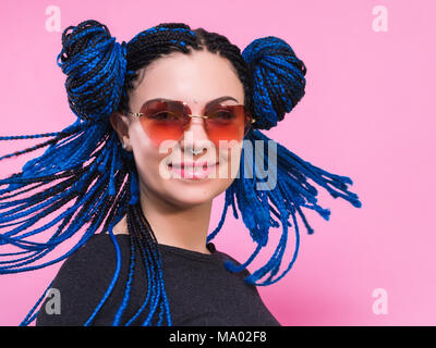 Close-up of woman with pigtails bleu tête tressé African girl with blue tresses, coiffure. Portrait Hipster girl with sunglasses sur fond coloré. Concept de vie. Banque D'Images