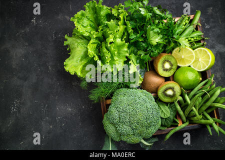 Les légumes verts. Le brocoli, épinards, kiwi, Laitue, Persil, aneth, haricots asperges sur table béton foncé. La nourriture végétarienne. Vue d'en haut Banque D'Images