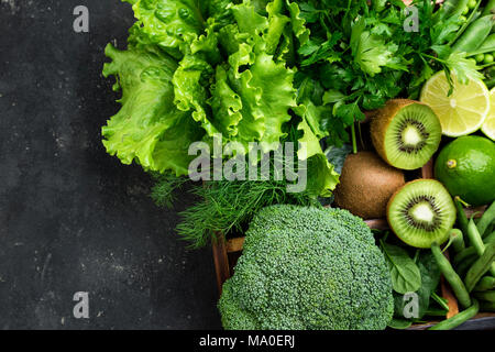 Les légumes verts. Le brocoli, épinards, kiwi, Laitue, Persil, aneth, haricots asperges sur table béton foncé. La nourriture végétarienne. Vue d'en haut Banque D'Images
